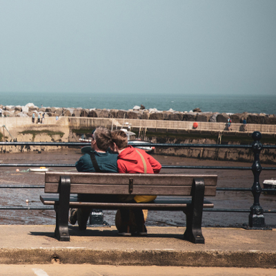 couple sat on a bench at the seaside